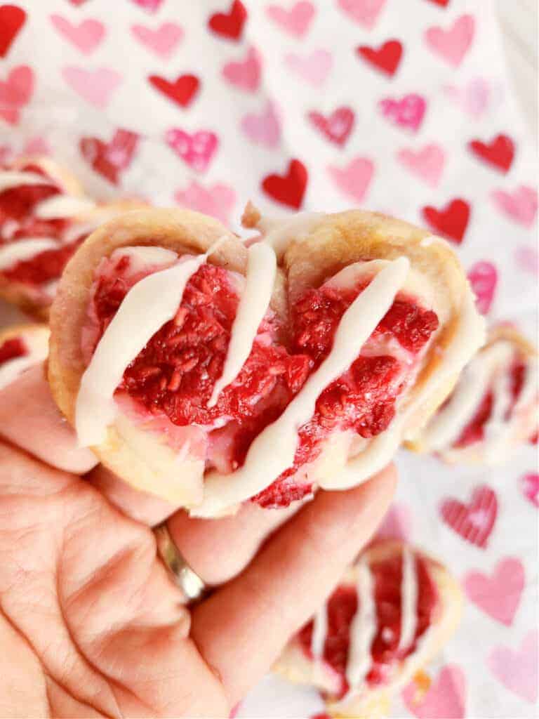 close up of a heart shaped raspberry cream cheese danish pastry.
