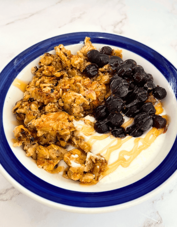 A high protein breakfast bowl of granola with raisins and yogurt.