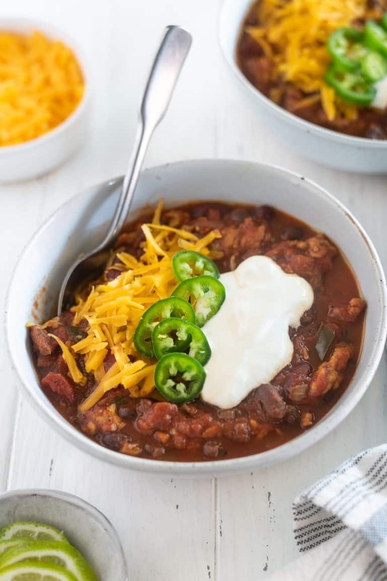 Slow cooker turkey chili in a bowl with toppings 
