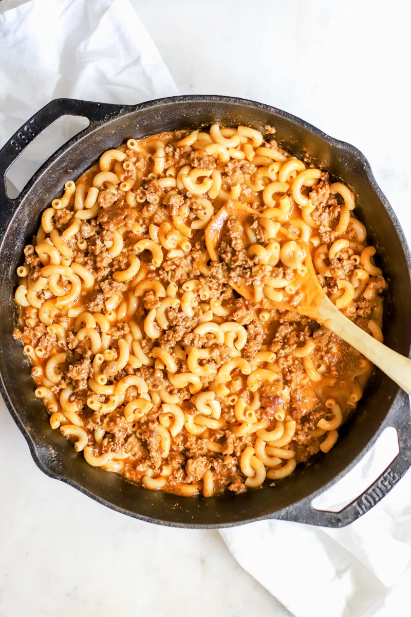 A cast iron skillet with venison hamburger helper showing this simple ground venison recipe. 
