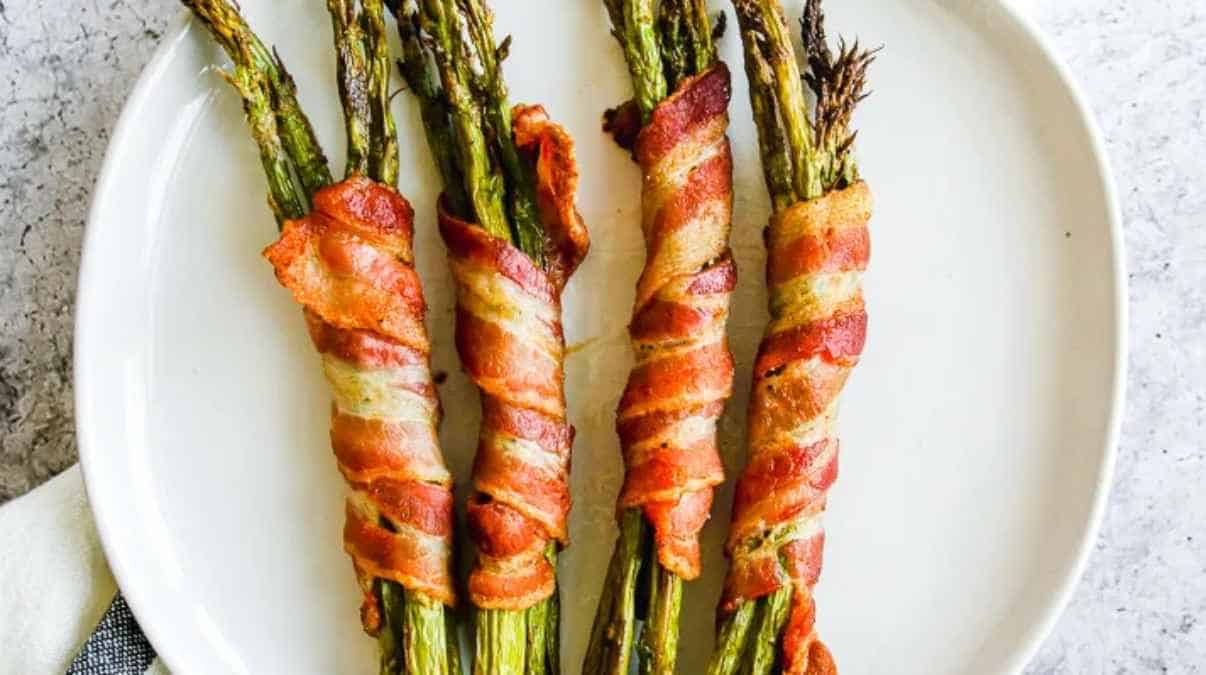 Asparagus wrapped in bacon on a plate.