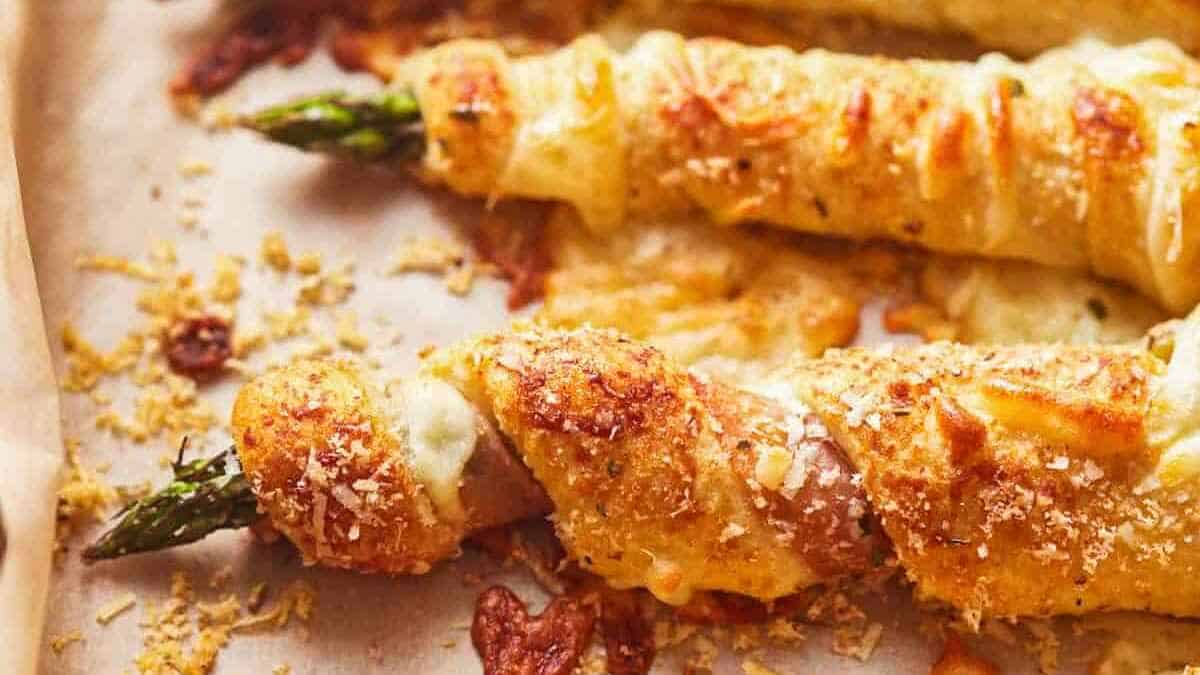 Asparagus spears wrapped in puff pastry and cheese, baked until golden brown.