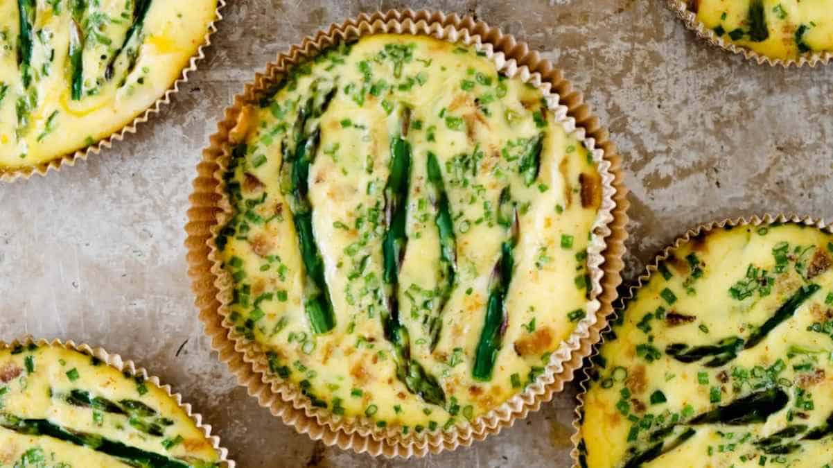 Freshly baked mini quiches with asparagus and herbs.