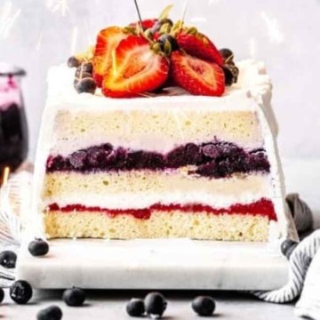 A cake with strawberries and blueberries.