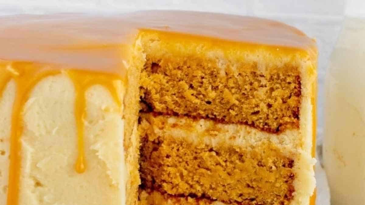 A slice of pumpkin cake with caramel sauce on top.