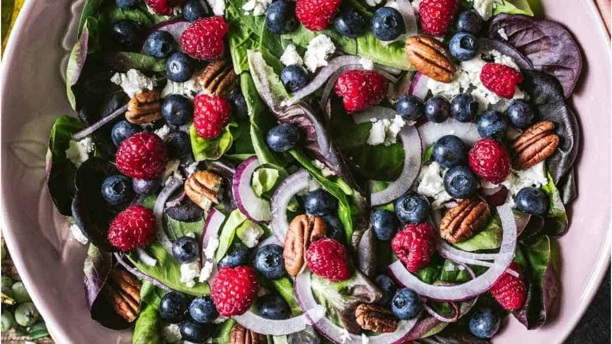 A salad with blueberries, pecans and walnuts.