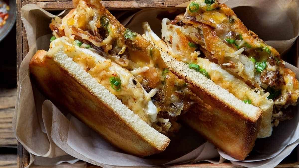 Two sandwiches in a wooden box on a table.
