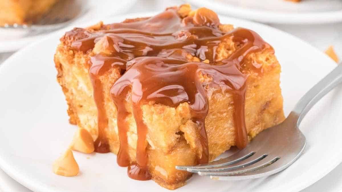 A slice of bread pudding with caramel sauce on a plate.