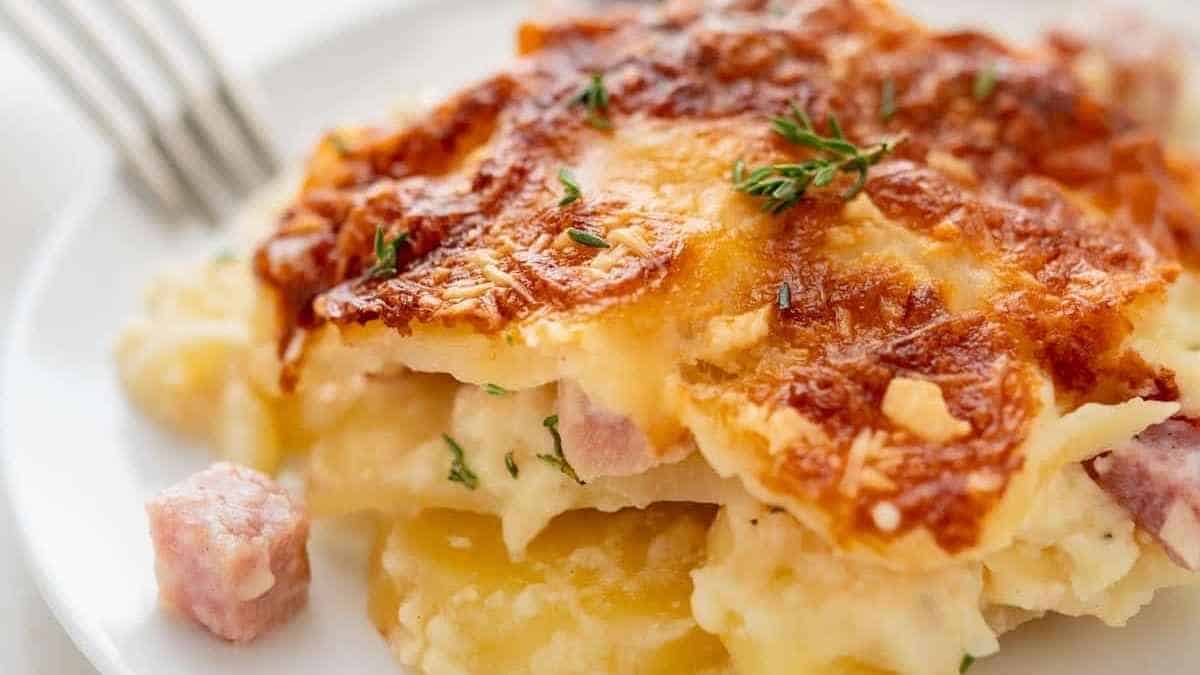 Ham and cheese casserole on a plate with a fork.