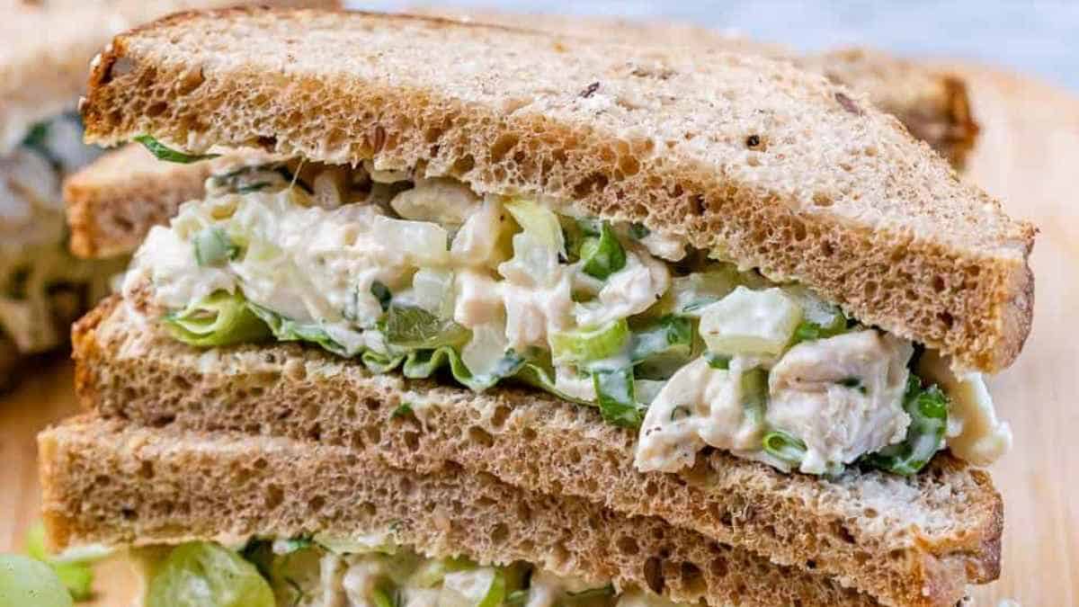 Chicken salad sandwich on whole grain bread with lettuce.