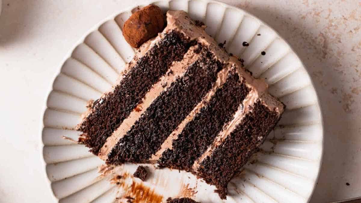A slice of chocolate layer cake on a white plate.
