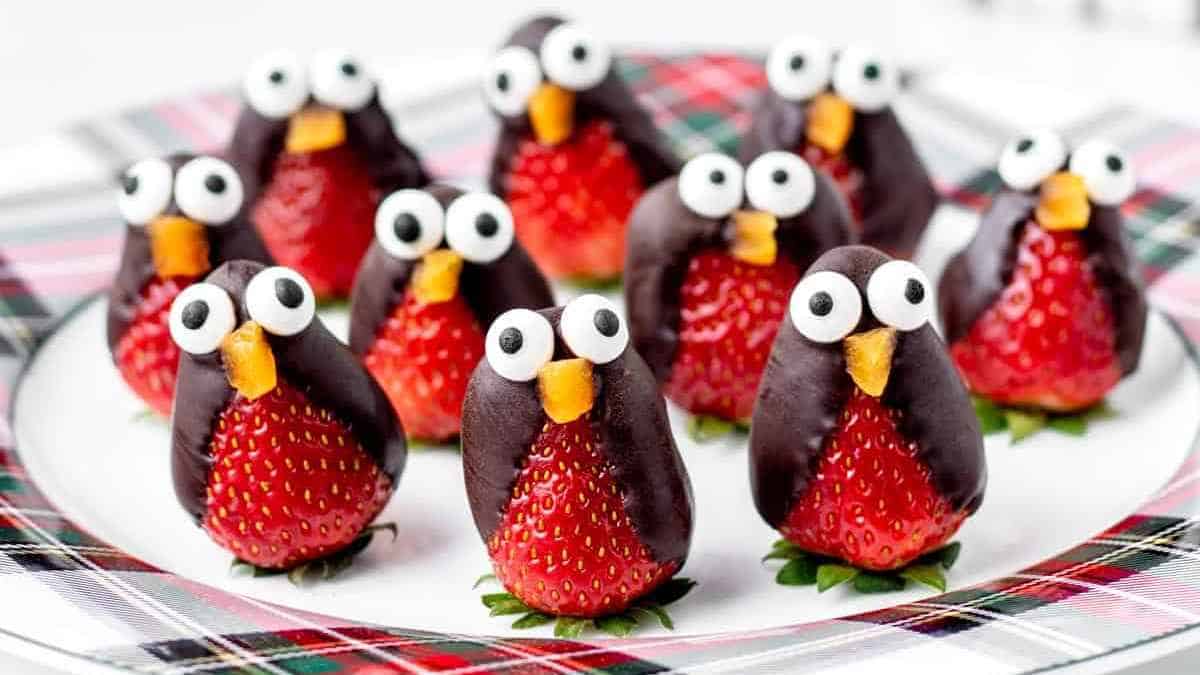A plate of strawberries with googly eyes.
