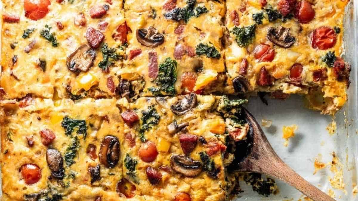 Breakfast casserole with mushrooms and tomatoes on a baking sheet.