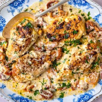 A plate of creamy chicken with a rich sauce and garnished with herbs.