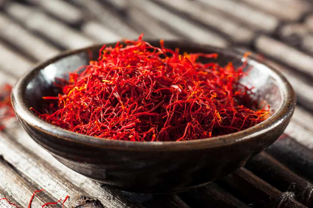 Saffron in a bowl on a wooden table.
