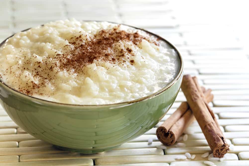 A bowl of rice with cinnamon and cinnamon sticks.