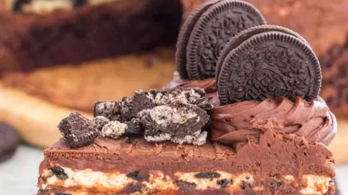 A slice of chocolate cheesecake garnished with oreo cookies.