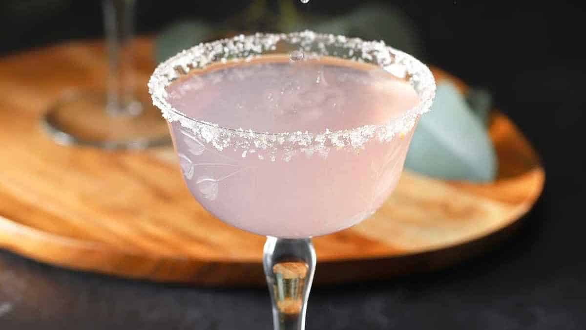 A pink margarita being poured into a glass.