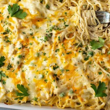 A baked cheesy pasta dish garnished with parsley in a white casserole.