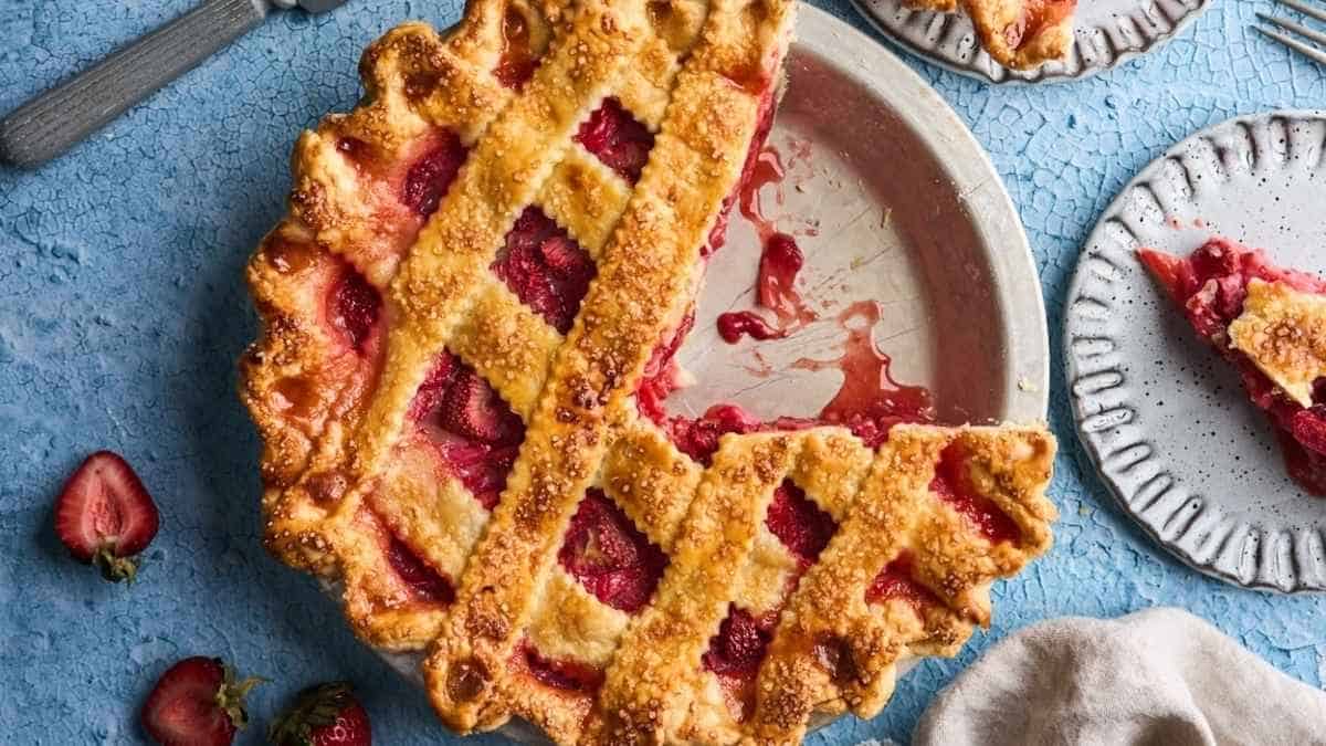 A strawberry pie with a slice taken out.