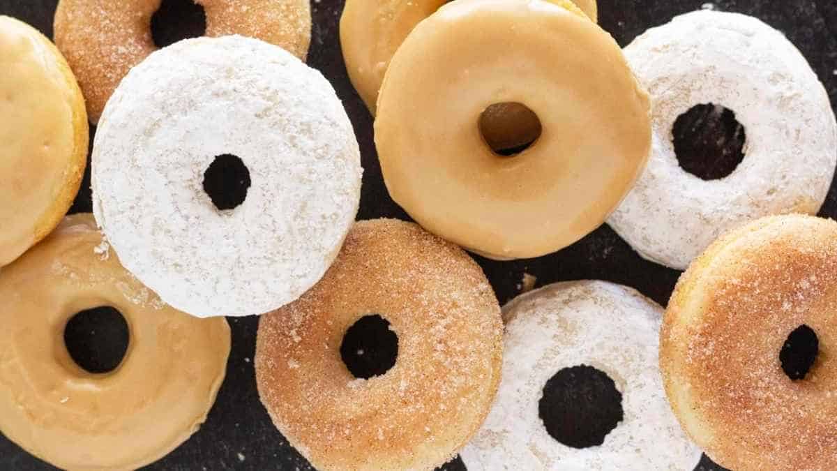 A group of donuts are arranged on a black surface.