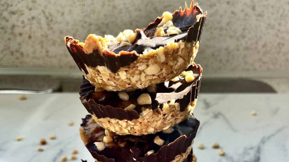 A stack of chocolate peanut butter cups with nut toppings.