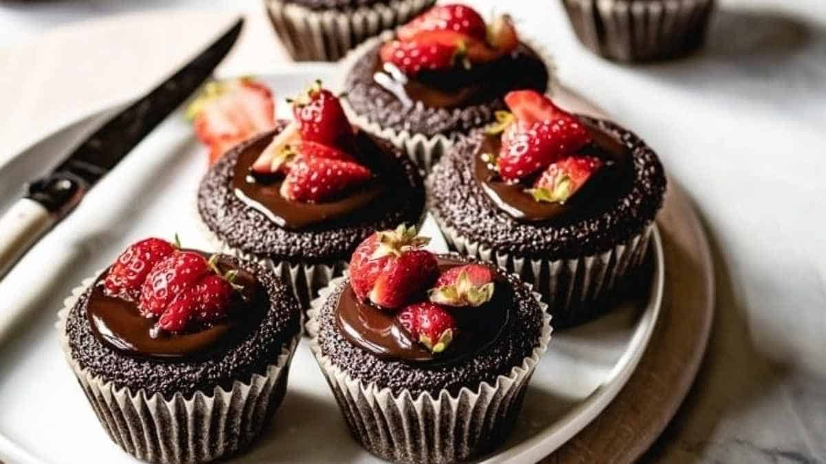 Chocolate cupcakes with strawberries on a plate.