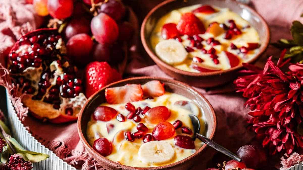 Bowls of fruit and yogurt with a spoon.