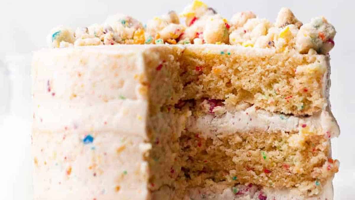 A slice of vanilla funfetti cake with rainbow sprinkles and buttercream frosting.
