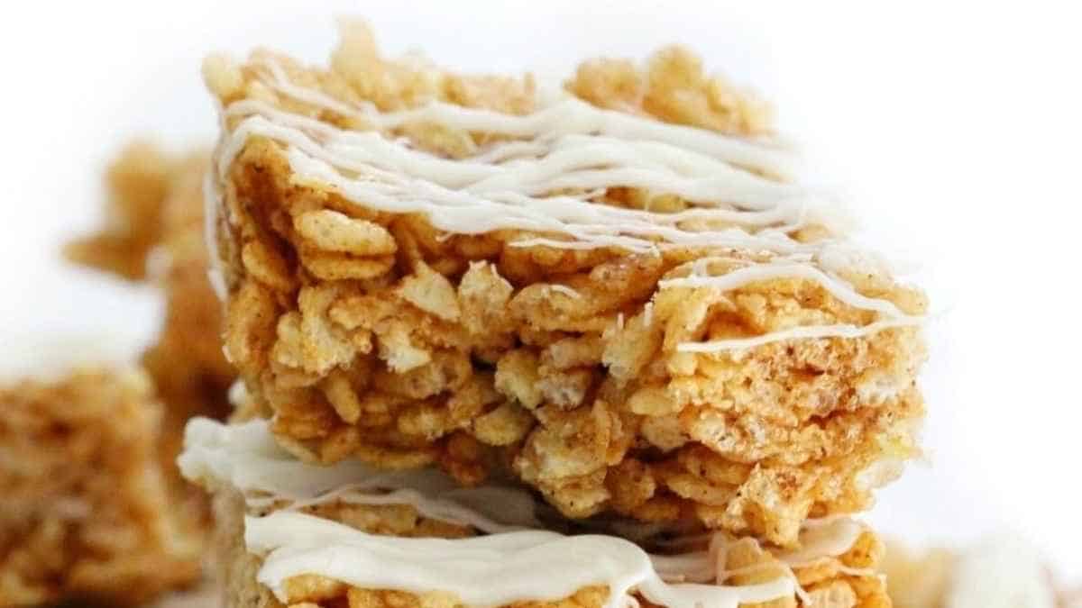 A stack of rice krispie treats with icing on top.