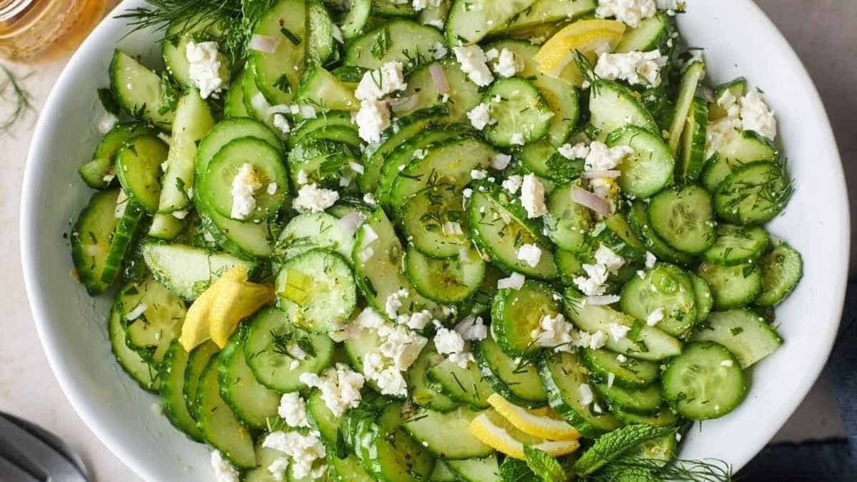 A bowl of cucumber salad with feta and lemon.