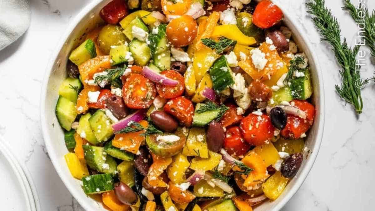 Greek vegetable salad in a white bowl.
