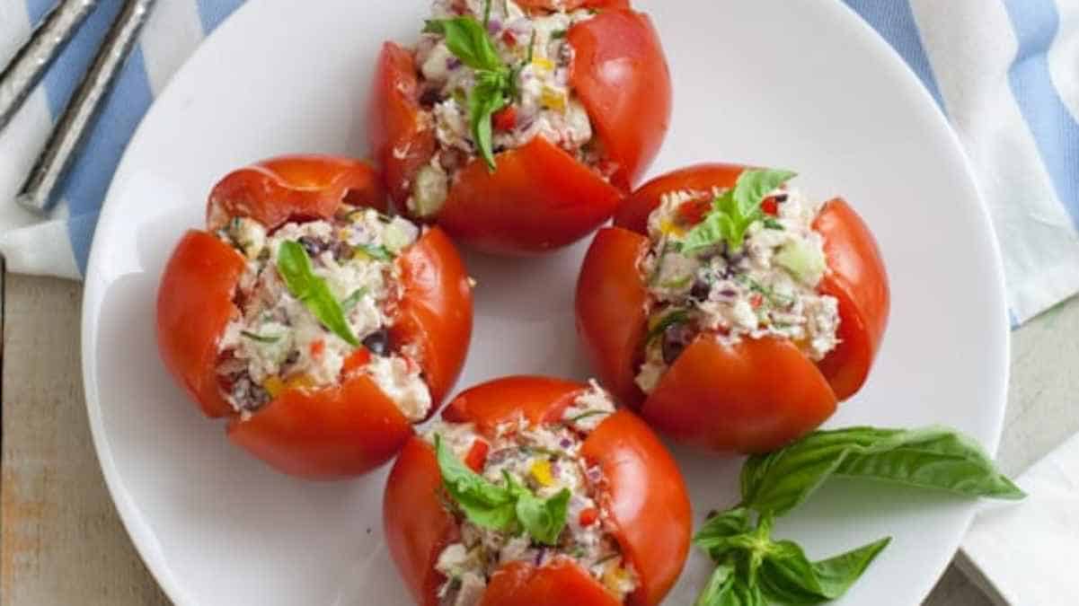 Stuffed tomatoes on a plate garnished with basil.