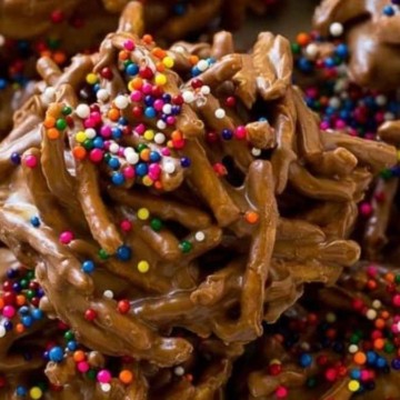 A plate of chocolate covered cookies with sprinkles.