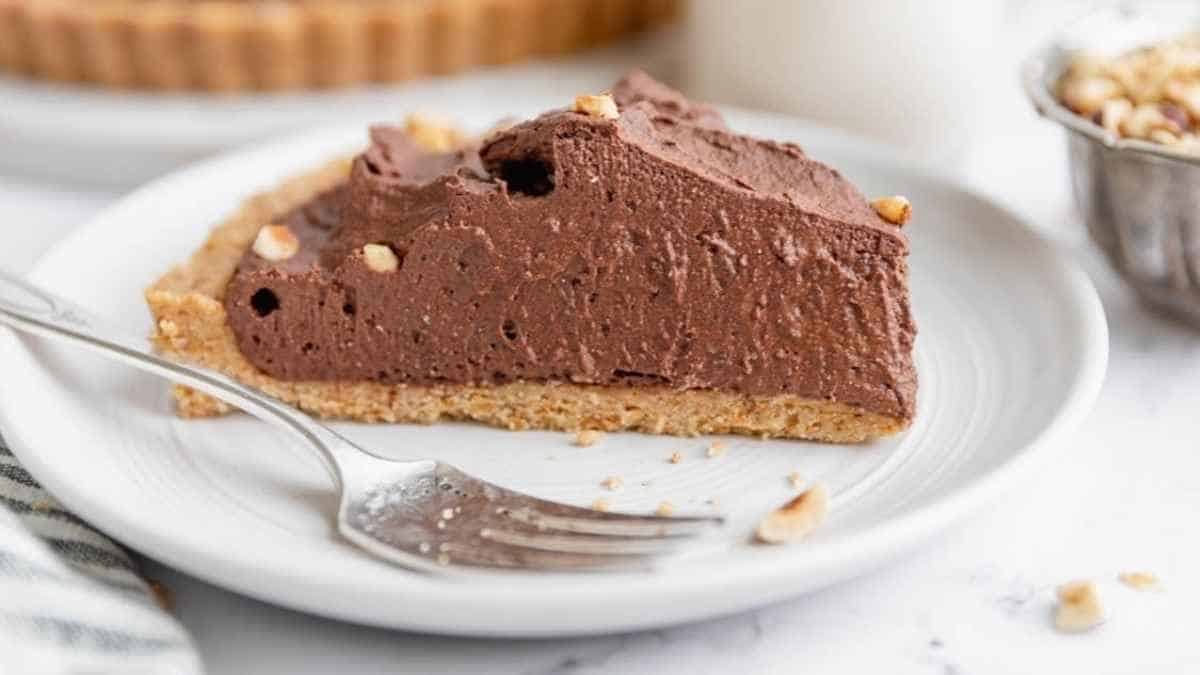 A slice of chocolate pie on a plate with a fork.