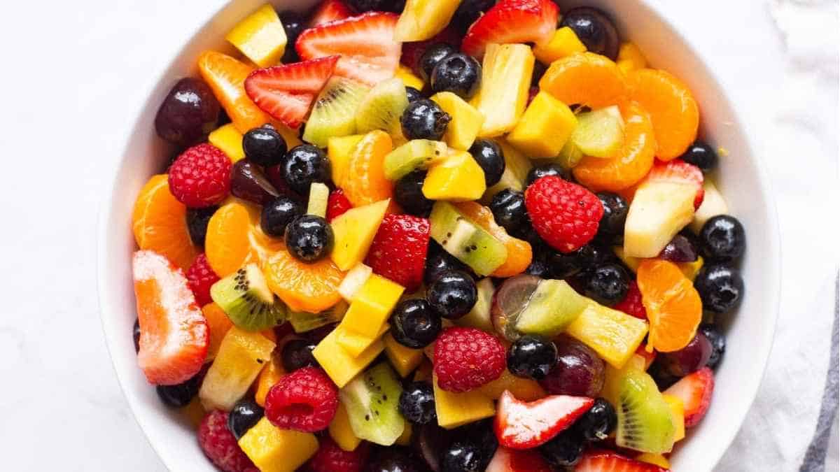Fresh fruit salad in a white bowl.