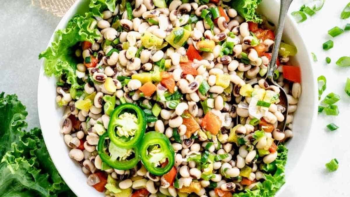 A fresh black-eyed pea salad garnished with jalapeño slices and chopped vegetables.