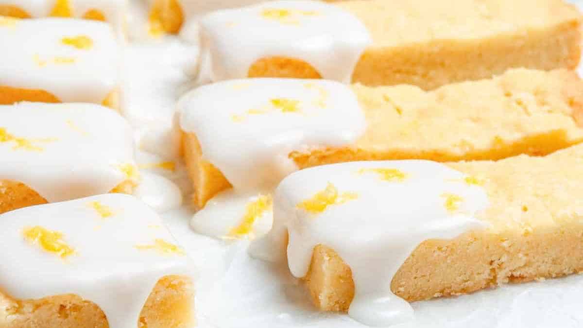 Slices of lemon drizzle cake with white icing on top.