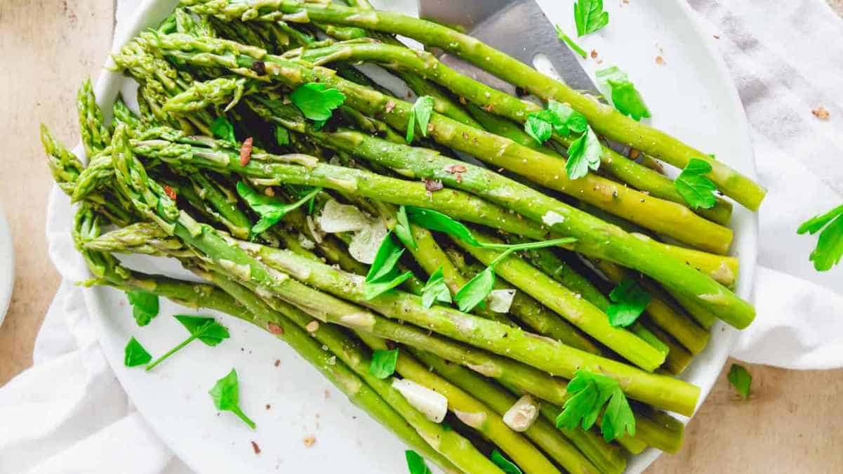 A plate of seasoned asparagus garnished with parsley.