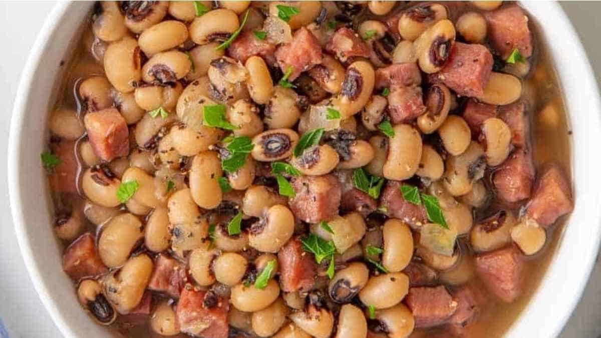 A bowl of black-eyed peas with diced ham and herbs.