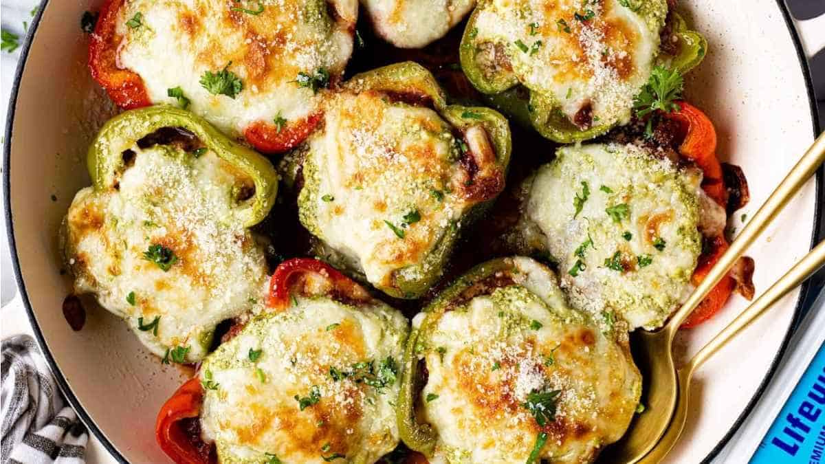 Stuffed peppers in a skillet with parmesan cheese.