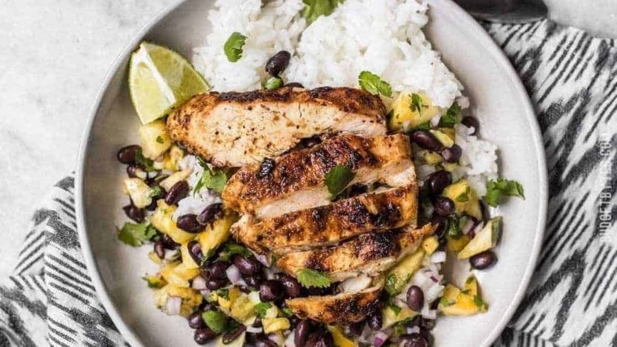 Grilled chicken with black beans and rice on a plate.
