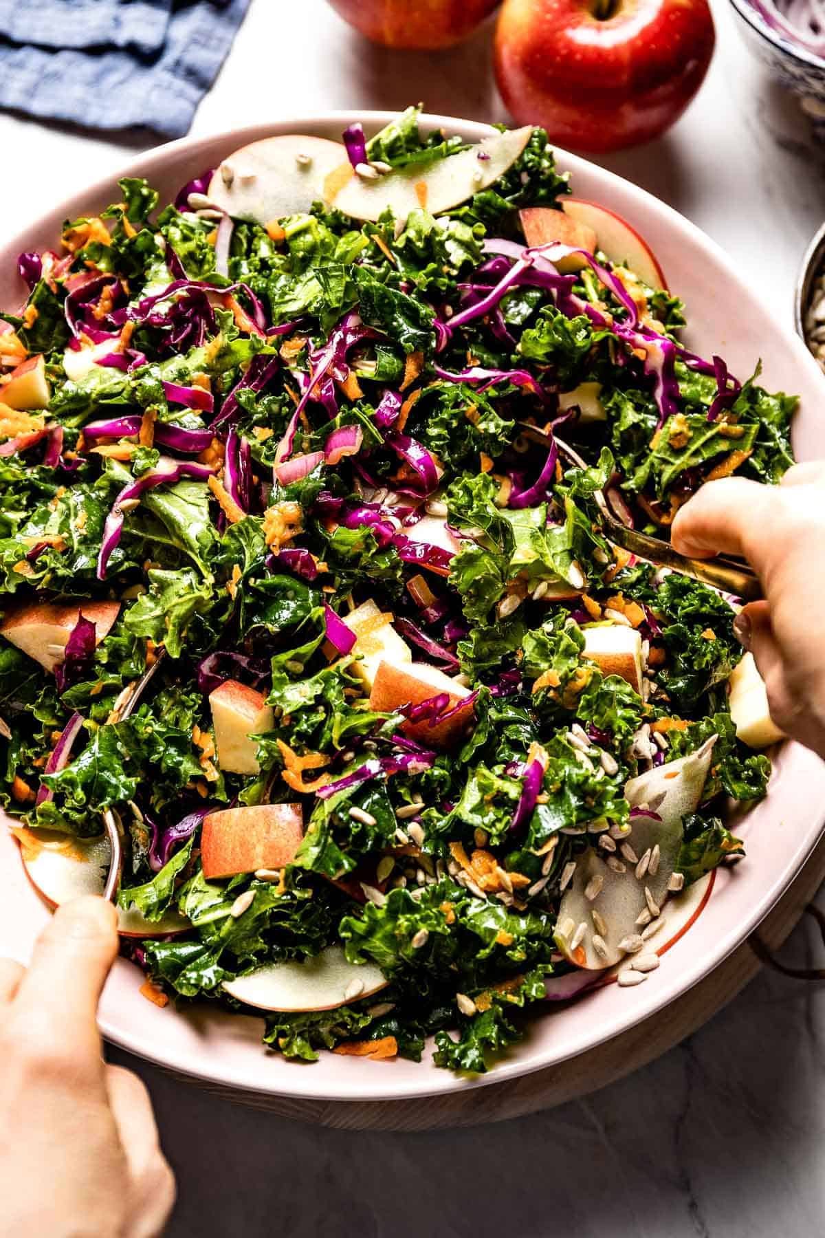 person tossing kale slaw from top view.