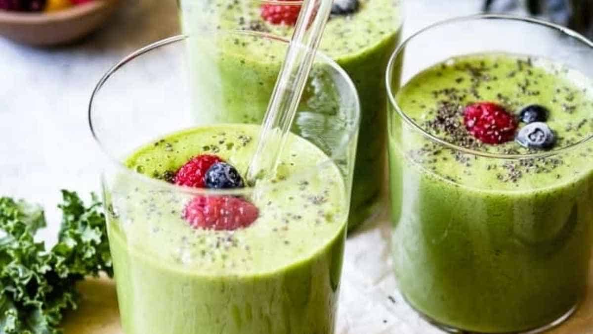 Two glasses of green smoothie with berries and chia seeds.