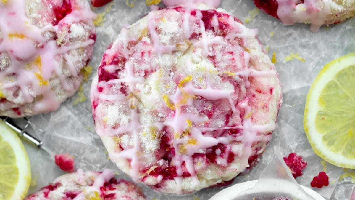 Lemon raspberry cookies with glaze on parchment paper.