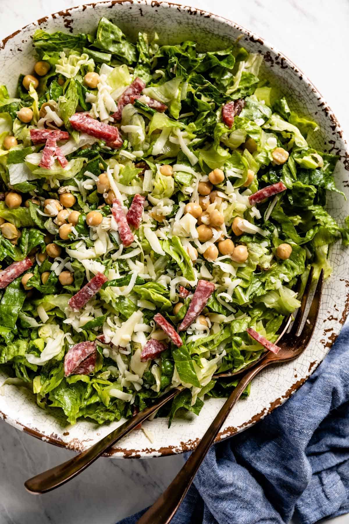 An Italian salad in a bowl with forks from the top view. 
