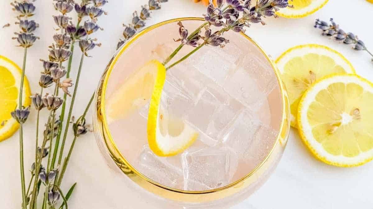 A pink drink with lemon slices and lavender flowers.