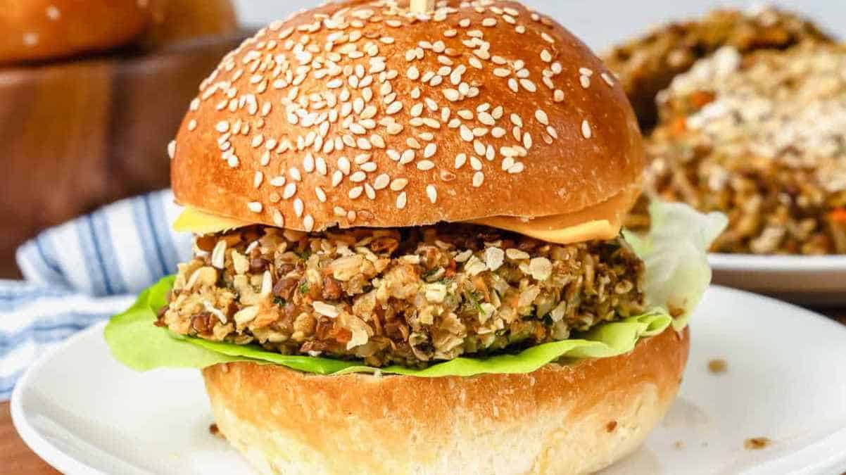 A veggie burger with a sesame seed bun, lettuce, and cheese.