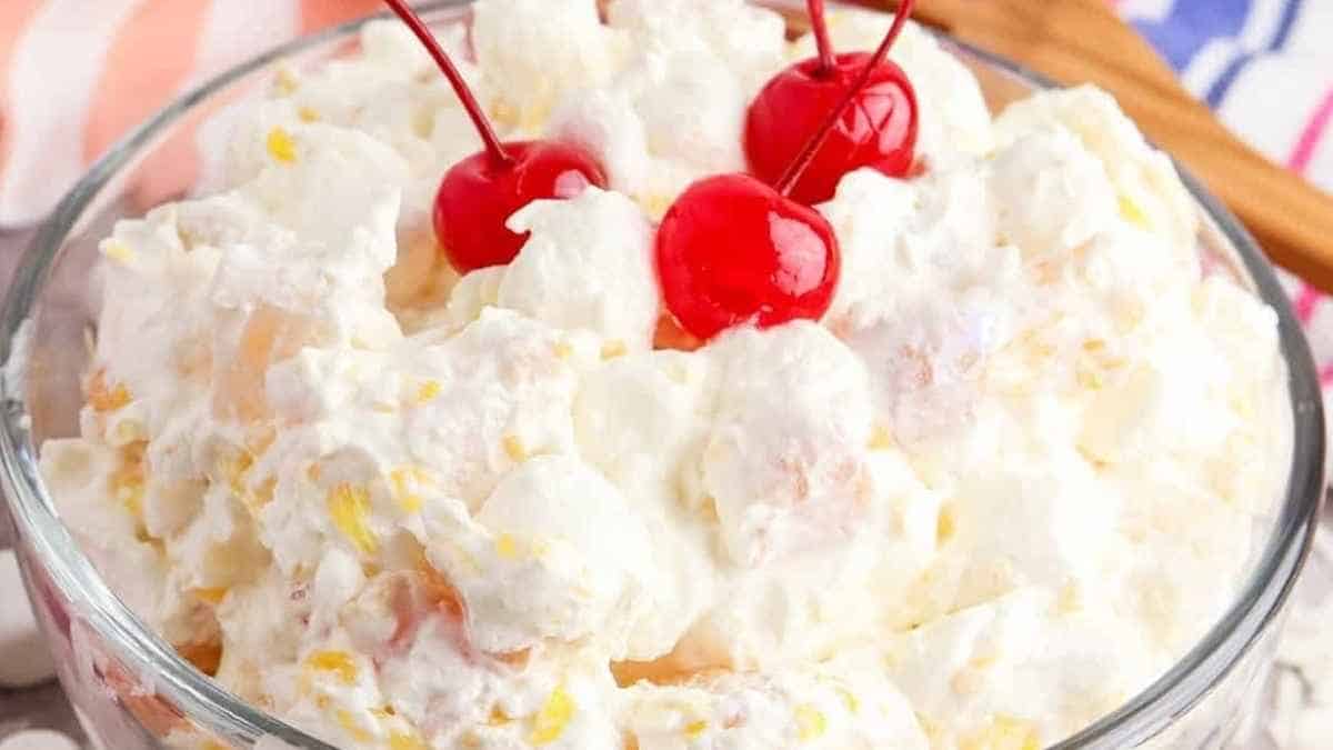 A bowl filled with whipped cream and cherries.