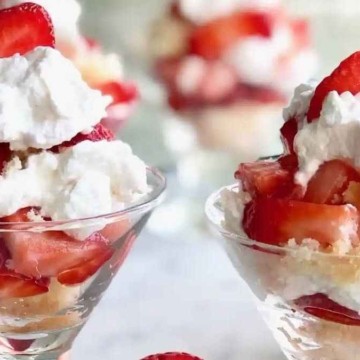 Strawberry shortcake in a glass with whipped cream and strawberries.